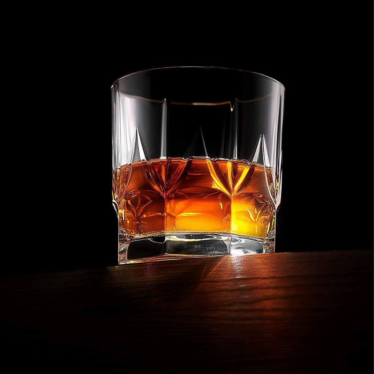 Clear glass filled with amber liquid on a dark background